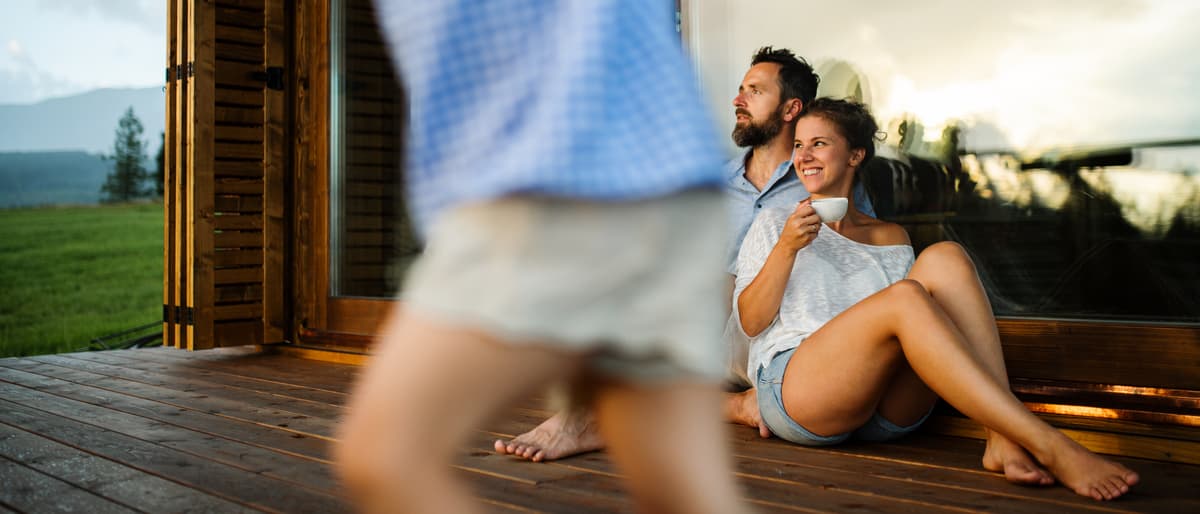 A family relaxing together on the porch of a home